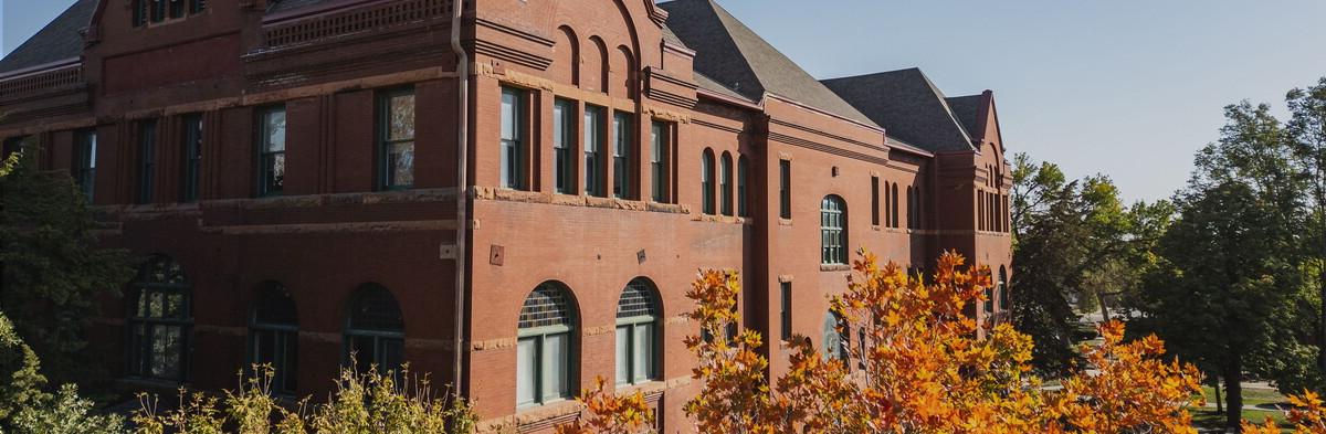 Trees in fall colors surround the top of the Old Main building.